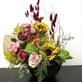 Mixed bouquet with roses, sunflowers, and green hydrangeas in a black vase