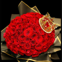 Large bouquet of red roses with a decorative crown on black wrapping