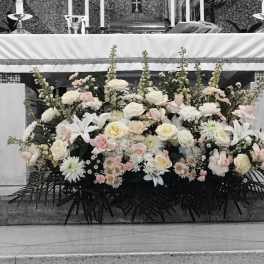 Large white and blush floral arrangement in front of an altar