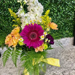Mixed bouquet with a magenta gerbera daisy and white flowers in a glass vase