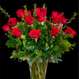 Red roses arranged in a clear glass vase