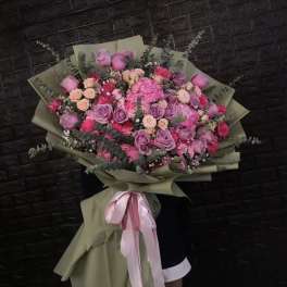 Large bouquet of pink and purple roses wrapped in olive paper