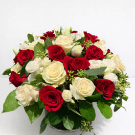 Red and white rose bouquet in a low round container