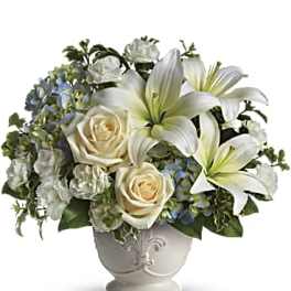 White lilies and cream roses in a decorative vase