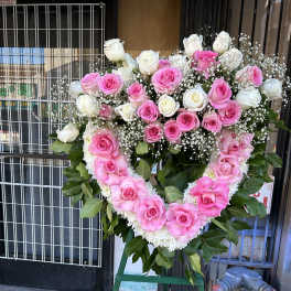 Heart-shaped pink and white rose standing spray on an easel