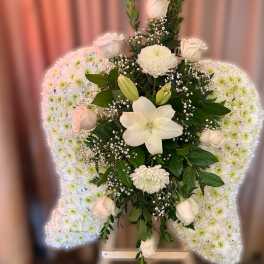 Standing white floral arrangement with chrysanthemum wings and central roses and lilies