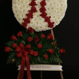 Baseball-themed white and red standing funeral spray on an easel with a red rose accent spray