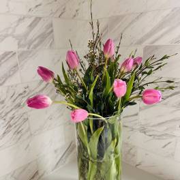Pink tulips arranged in a clear glass vase