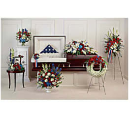 Funeral casket spray and wreaths in red, white, and blue