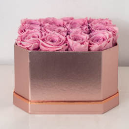 Pink roses arranged in a tight grid inside a rose gold rectangular box