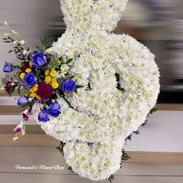 Standing white chrysanthemum ribbon arrangement with blue roses and mixed accent flowers.