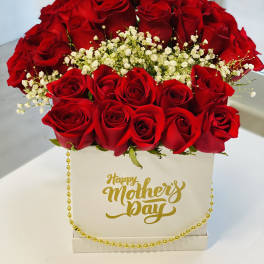 Red roses arranged in a white box with a gold Happy Mother's Day message