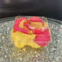 Clear plastic box of pink and yellow rose petals