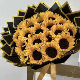 Bouquet of sunflowers wrapped in black and gold paper