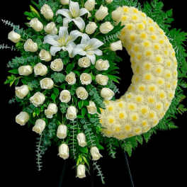 Standing crescent spray of white roses, lilies, and pale yellow chrysanthemums on an easel