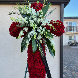 Large red rose standing spray with white orchids on an easel