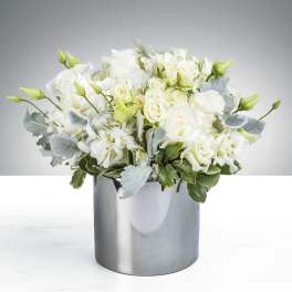Compact white rose and hydrangea arrangement in a shiny silver cylinder vase