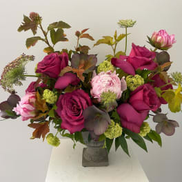 Bouquet of magenta roses and pink peonies in a gray vase