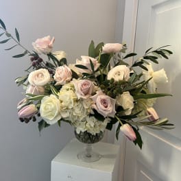 Blush and white roses with tulips in a clear glass vase