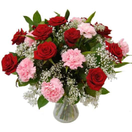 Bouquet of red roses and pink carnations in a glass vase