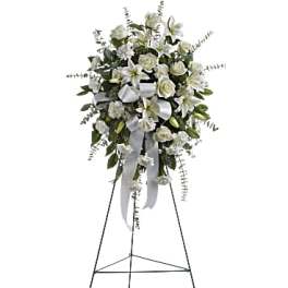 White floral standing spray on an easel with ribbon streamers