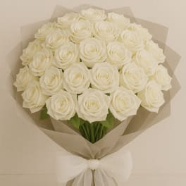 Bouquet of white roses wrapped in beige paper with a white bow