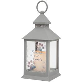 Gray memorial lantern with a candle and "Forever in our hearts" text