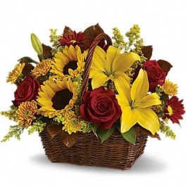 Basket arrangement with yellow lilies, sunflowers, and red roses