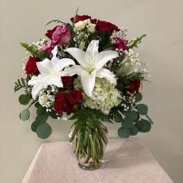 Bouquet of red roses and white lilies in a clear glass vase