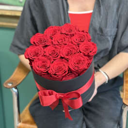 Round box of red roses tied with a red ribbon