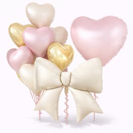 Cluster of pastel heart balloons with a large cream bow balloon