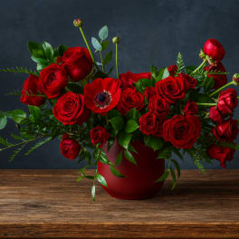 Red roses and a red poppy in a red vase