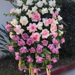 Large standing arrangement of pink, lavender, and white roses