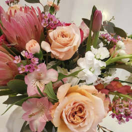 Bouquet of peach roses, pink protea, and white flowers