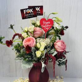 Pink and white rose arrangement in a burgundy vase with Valentine signs