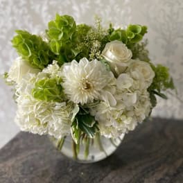 White and green bouquet in a clear glass vase