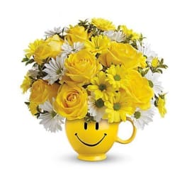 Yellow roses and white daisies in a smiley-face mug