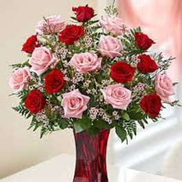 Bouquet of red and pink roses in a red glass vase