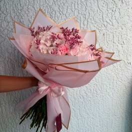 Pink bouquet with carnations and hydrangeas wrapped in pale pink paper