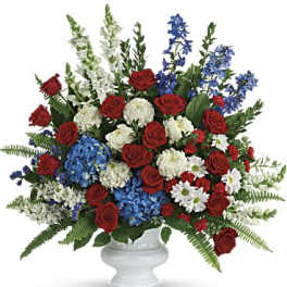 Red roses, blue and white flowers in a white vase