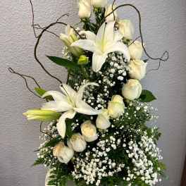 White lilies and cream roses in a white vase with baby's breath