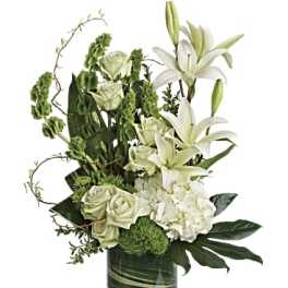White lilies and roses arranged in a green glass vase