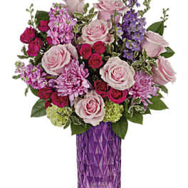 Pink and purple mixed flower bouquet in a purple vase