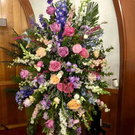 Large standing floral spray with pink, purple, and white flowers