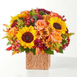 Autumn bouquet with sunflowers, roses, and mums in a textured vase