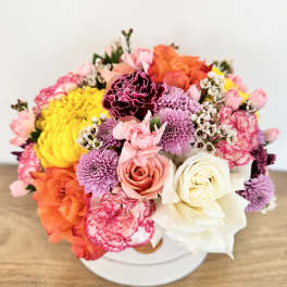 Colorful bouquet of roses, carnations, and chrysanthemums in a white box