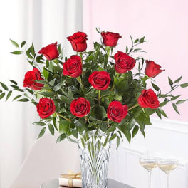 Red roses arranged in a clear glass vase