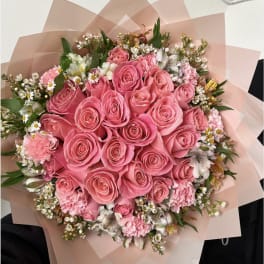 Pink rose bouquet with mixed small flowers wrapped in blush paper