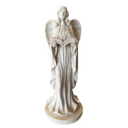 White angel statue holding an open book