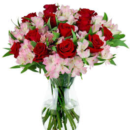 Vase arrangement of red roses and light pink alstroemeria in a clear glass vase